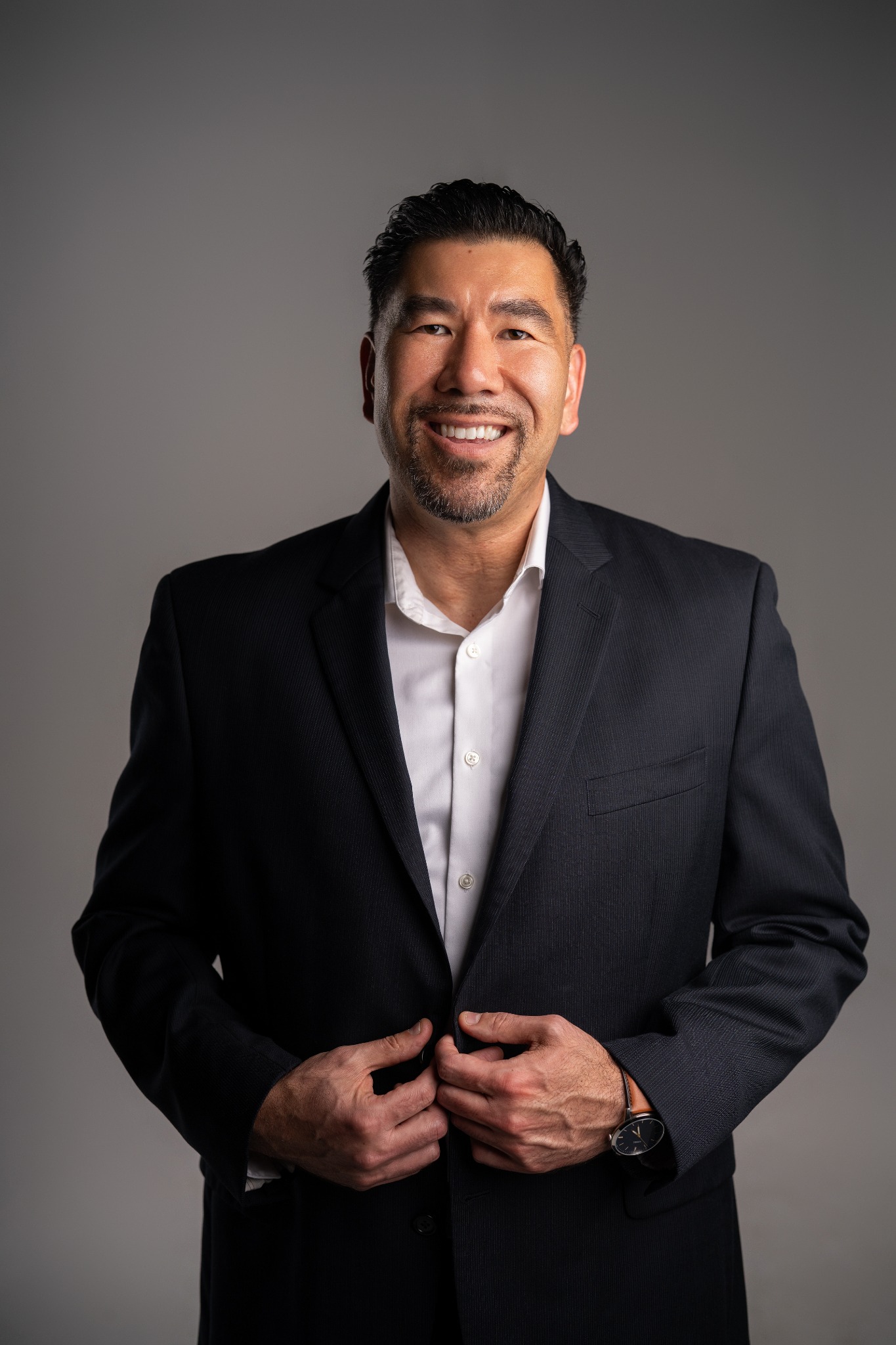 Joshua T. Hartnett smiling in a navy blazer